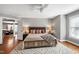 Well-lit bedroom with a wooden bed frame, ceiling fan, and doorway to a dining area at 115 Ripplewater Ln, Cary, NC 27518