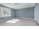 Bright bedroom featuring a ceiling fan, neutral carpet, closet and large window at 115 Ripplewater Ln, Cary, NC 27518