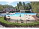 Community pool area with lounge chairs, tables and umbrellas surrounded by a black metal fence at 115 Ripplewater Ln, Cary, NC 27518