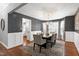 Dining room features a modern chandelier, paneled walls, and a view to the kitchen at 115 Ripplewater Ln, Cary, NC 27518