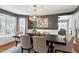 Dining room boasts stylish chandelier, modern furniture, and gray paneled walls at 115 Ripplewater Ln, Cary, NC 27518