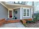 Covered front porch with brick steps and a decorative wreath for a welcoming entrance at 115 Ripplewater Ln, Cary, NC 27518