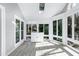 Bright sunroom with skylight, light-colored tile floor, many windows, and white cabinet at 115 Ripplewater Ln, Cary, NC 27518