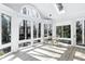 Sunroom filled with natural light boasts a skylight, arched windows, and neutral color palette at 115 Ripplewater Ln, Cary, NC 27518