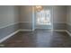 Dining room with hardwood floors, chair rail, and large window at 11928 Straight A Way Ln, Raleigh, NC 27613