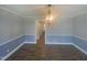 Dining room featuring hardwood floors, modern lighting fixture, and open doorway at 11928 Straight A Way Ln, Raleigh, NC 27613