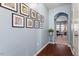 Hallway with hardwood floors, light blue walls, and arched entry, flowing into the living room at 127 Lakemont Dr, Clayton, NC 27520