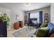 Bright and airy office space with a blue couch, wooden desk, and blue floral rug at 127 Lakemont Dr, Clayton, NC 27520