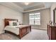 Cozy bedroom with plush carpeting, a tray ceiling, and ample natural light at 129 Oban Dr, Homesite 150, Sanford, NC 27330