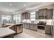 Well-lit kitchen with gray cabinets, stainless steel appliances, and white countertops at 129 Oban Dr, Homesite 150, Sanford, NC 27330