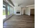 Bright living room with hardwood floors, a modern fireplace, a ceiling fan, and access to the backyard at 129 Oban Dr, Homesite 150, Sanford, NC 27330