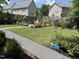 Charming backyard with pea gravel pathway, lush greenery, and a cozy seating area surrounded by flowers and plants at 13 Piccadilly Ct, Durham, NC 27713