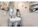 Powder room featuring a pedestal sink, stylish mirror, and decorative bird artwork at 13 Piccadilly Ct, Durham, NC 27713