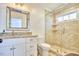 Well-lit bathroom with granite counters, decorative mirror, and glass-enclosed shower stall at 1400 Oakland Ave, Durham, NC 27705