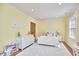 Cheerful bedroom with yellow walls, hardwood floors and white furnishings at 1400 Oakland Ave, Durham, NC 27705