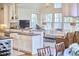 Open-concept living space with a kitchen bar, stone fireplace, and ample natural light from large windows at 1400 Oakland Ave, Durham, NC 27705