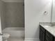 Well-lit bathroom with granite vanity top, dark cabinets, and tiled shower-tub combo at 143 Prency Ln, Middlesex, NC 27557