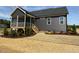 Exterior view of a home with dark siding, a screened porch, and a well-maintained yard at 143 Prency Ln, Middlesex, NC 27557