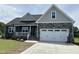 Charming home featuring a two-car garage, stone accents, and well-manicured lawn at 143 Prency Ln, Middlesex, NC 27557