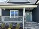 Inviting covered front porch with stone base and green front door at 143 Prency Ln, Middlesex, NC 27557