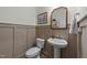 Stylish half bathroom featuring pedestal sink, decorative mirror, and wainscoting at 158 Arlie Ln, Lillington, NC 27546