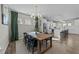 Bright dining room with a wooden table, stylish black chairs, and modern chandelier adjacent to a white kitchen at 158 Arlie Ln, Lillington, NC 27546