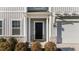 A charming black front door highlighted by stone accents and a pergola above the two car garage at 158 Arlie Ln, Lillington, NC 27546