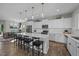 Open kitchen with white cabinets, an island with bar seating, stainless steel appliances, and pendant lights at 158 Arlie Ln, Lillington, NC 27546