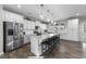 Spacious white kitchen with a large island, stainless steel appliances, and modern pendant lighting at 158 Arlie Ln, Lillington, NC 27546