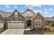 Charming home featuring stone and brick accents, a two-car garage, and a beautifully landscaped front yard at 170 Dunvegan Ln, Burlington, NC 27215