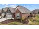 An attractive brick and stone home with lush landscaping and a well-maintained lawn offers great curb appeal at 170 Dunvegan Ln, Burlington, NC 27215
