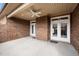 Cozy covered patio space made of red brick, concrete floor, and a fan for the comfort of outdoor living at 170 Dunvegan Ln, Burlington, NC 27215