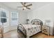 Bedroom with an ornamental metal frame bed, neutral walls, wood-look floor, and large windows at 1727 Pinecliff Ct, Fuquay Varina, NC 27526