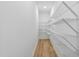 Walk-in closet showing white walls, wire shelving, and wood look floors at 1727 Pinecliff Ct, Fuquay Varina, NC 27526