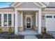 Close up of a front door with black door, sidelights, and nice landscaping at 1727 Pinecliff Ct, Fuquay Varina, NC 27526