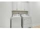 Laundry room featuring white washer and dryer set, white cabinets and neutral-tiled floor at 1727 Pinecliff Ct, Fuquay Varina, NC 27526
