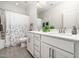 Bathroom with double vanity, white cabinets, modern fixtures, quartz countertop, and tiled floor with shower curtain at 1981 Rosedale Ridge Ave, Wake Forest, NC 27587