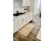 Stylish kitchen detail with white cabinets, quartz countertops, subway tile backsplash, and a trendy runner rug at 1981 Rosedale Ridge Ave, Wake Forest, NC 27587