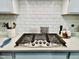 Modern gas cooktop with stainless steel finish and white subway tile backsplash at 1981 Rosedale Ridge Ave, Wake Forest, NC 27587