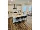 Open-concept kitchen with a large island, bar seating, stainless steel range hood and gray laminate flooring at 1981 Rosedale Ridge Ave, Wake Forest, NC 27587