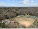 An aerial view of a baseball and tennis park surrounded by trees on a partially sunny day at 202 Harper Rd, Hillsborough, NC 27278