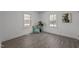 A bedroom featuring two windows, pillows, plants, and wood-look flooring at 202 Harper Rd, Hillsborough, NC 27278