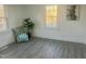 Charming bedroom showcasing gray floors, decorative pillows, a lush plant, and ample natural light from two windows at 202 Harper Rd, Hillsborough, NC 27278