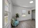 A bedroom featuring three windows, plants, a closet, and wood-look flooring at 202 Harper Rd, Hillsborough, NC 27278