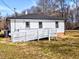 Ranch home exterior featuring a white ramp, dark roof, and low maintenance landscaping at 202 Harper Rd, Hillsborough, NC 27278