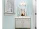 Well-lit bathroom featuring white vanity with marble countertop, decorative mirror and window with white blinds at 2110 Crigan Bluff Dr, Cary, NC 27513