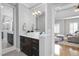 Bright bathroom featuring a sleek vanity, a decorative mirror, and a view into the main bedroom at 2110 Crigan Bluff Dr, Cary, NC 27513