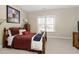 Comfortable bedroom with a wood-framed bed, soft carpet, and large window letting in natural light at 2110 Crigan Bluff Dr, Cary, NC 27513