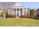 Stately brick home with large columns, black shutters, and well-maintained landscaping on a sunny day at 2110 Crigan Bluff Dr, Cary, NC 27513