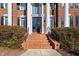 Inviting brick steps lead to a grand entrance with black double doors and elegant architectural details at 2110 Crigan Bluff Dr, Cary, NC 27513